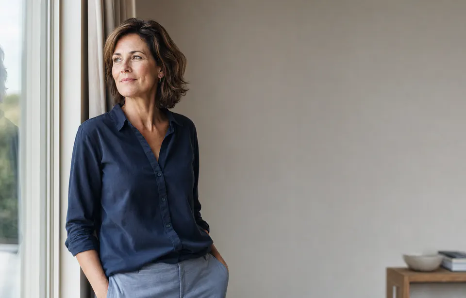 Zelfverzekerde ondernemer kijkt met een rustige glimlach naar buiten